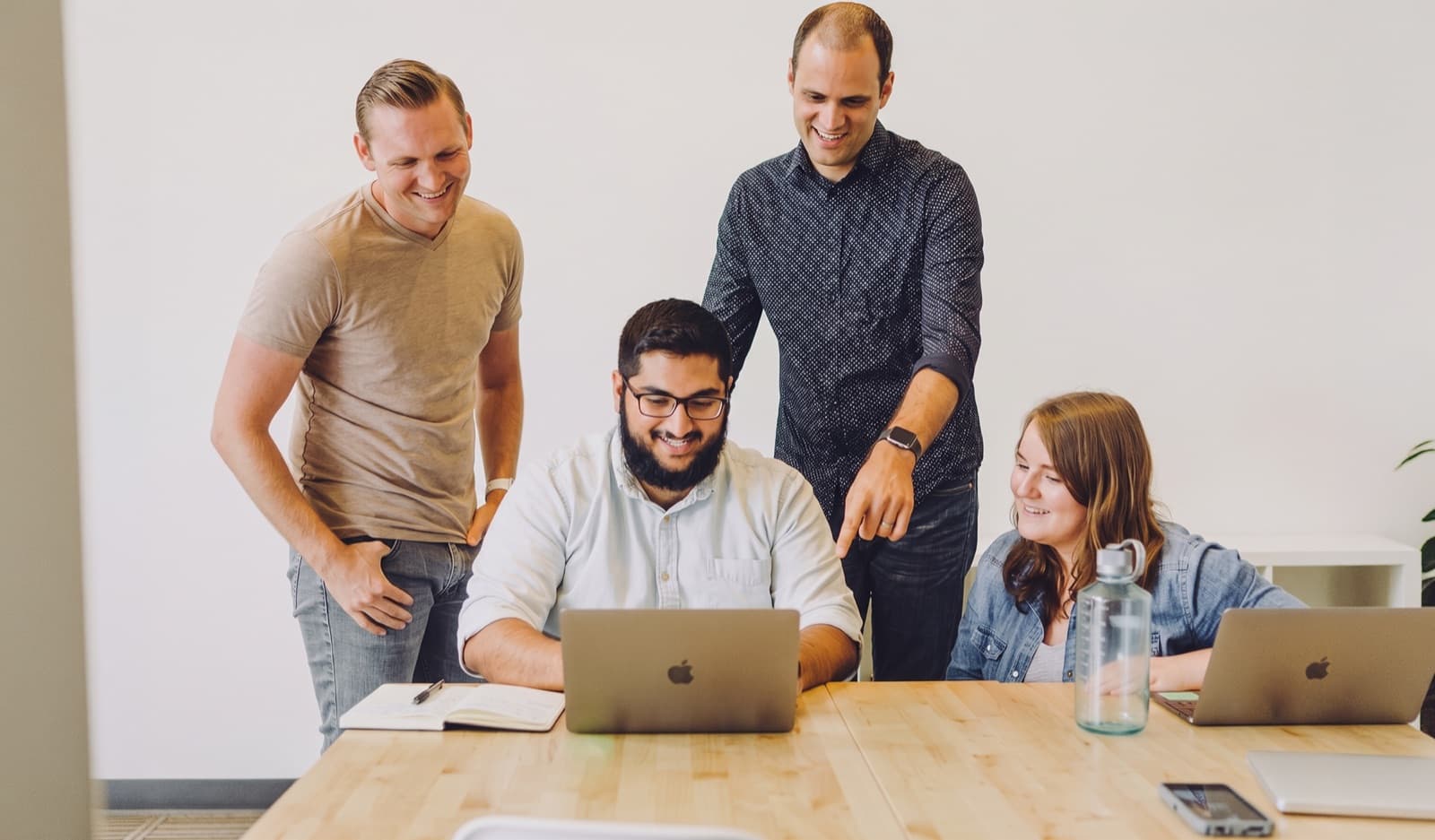 The Comonic team collaborating around a laptop